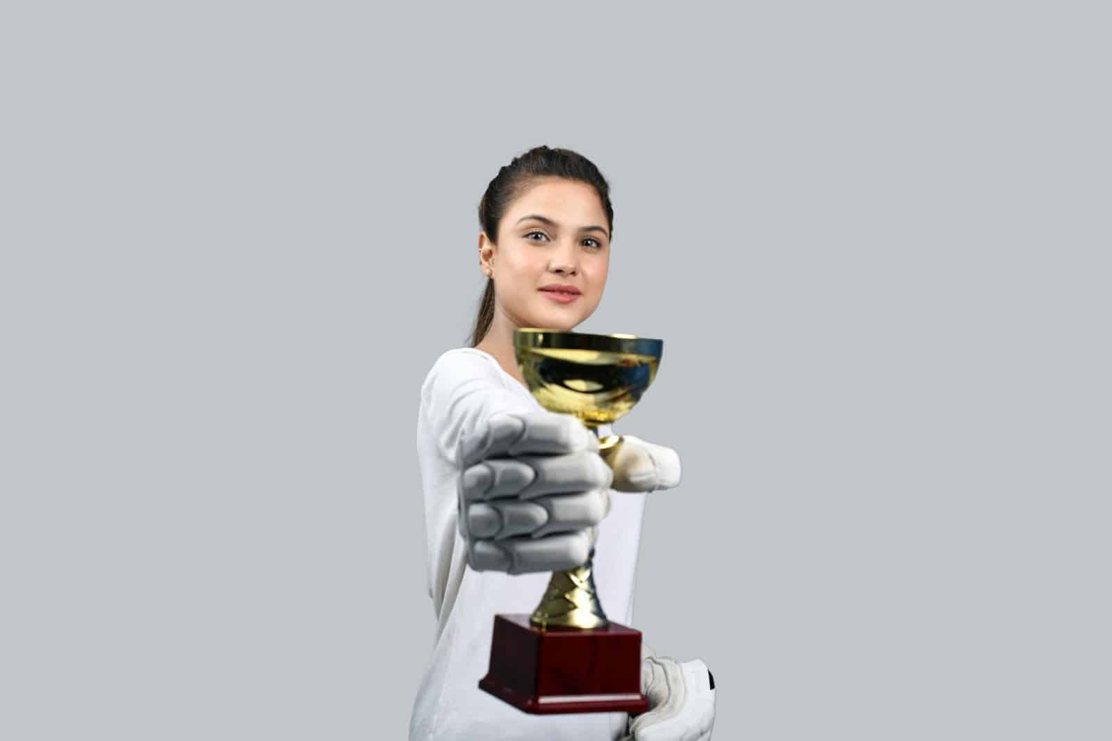 woman holding a trophy showing her achievement that she earned because of weekly review for personal development.