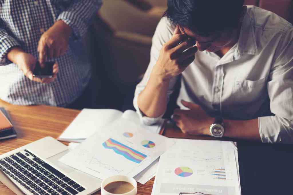 Employee at desk being watched by his paranoid boss
