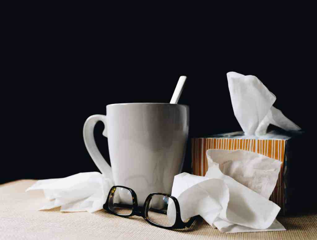 desk with box of tissues sick worker flu at the office pandemic wellness