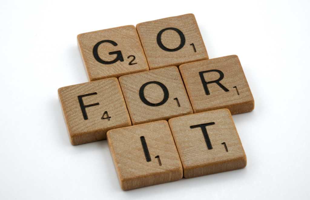 Wooden scrabble tiles spell out Go For It to avoid Analysis Paralysis