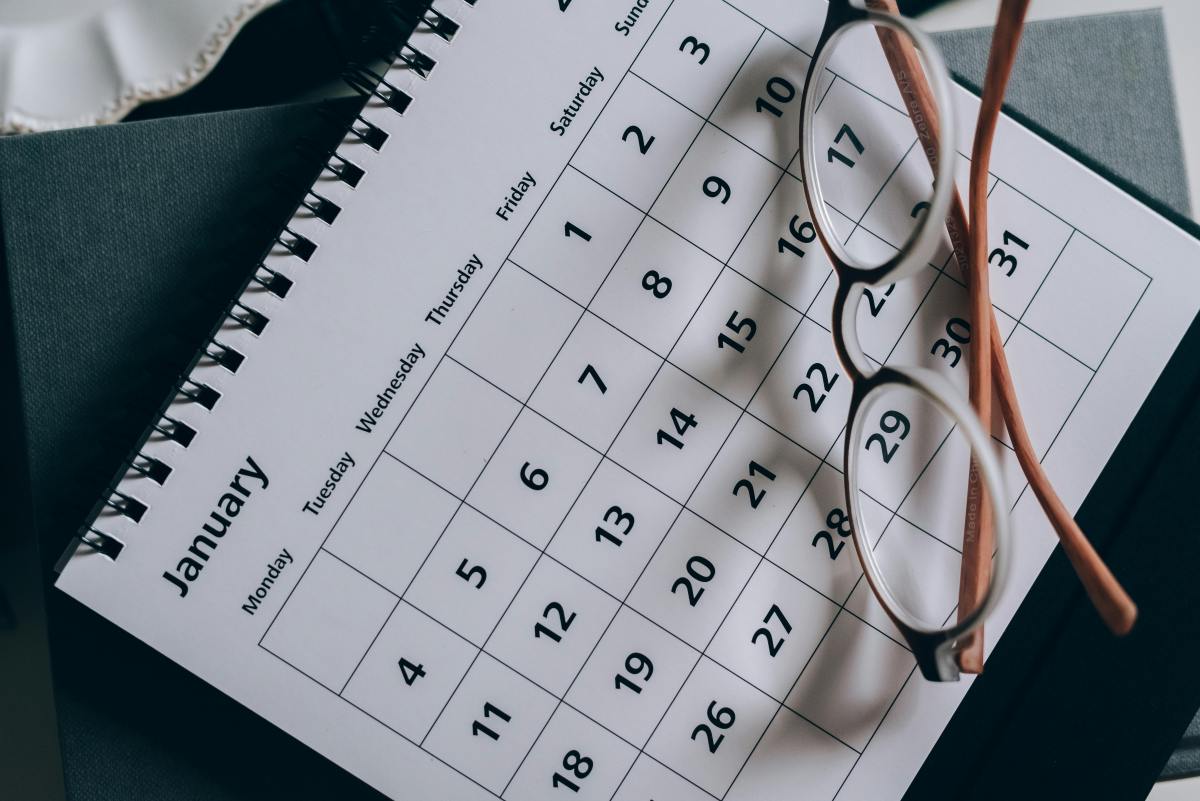 Open calendar with glasses, symbolizing planning and Monday Motivation through intentional scheduling.