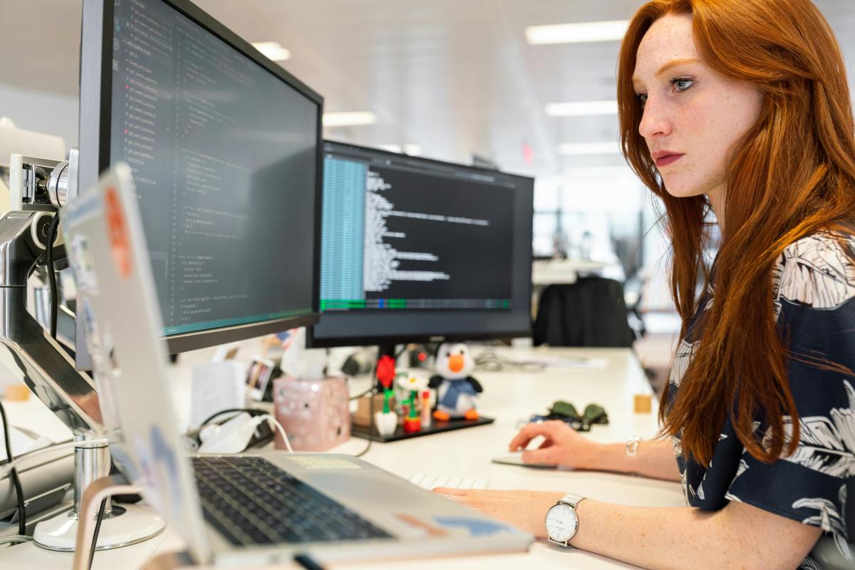 Woman coding on computer – deep work session to rebuild focus and recover from short attention span.