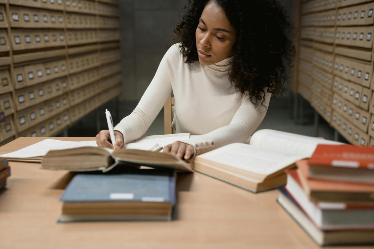woman researching in a quiet library, offering a calming contrast to phone addiction and illustrating the benefits of focused, screen-free environments.